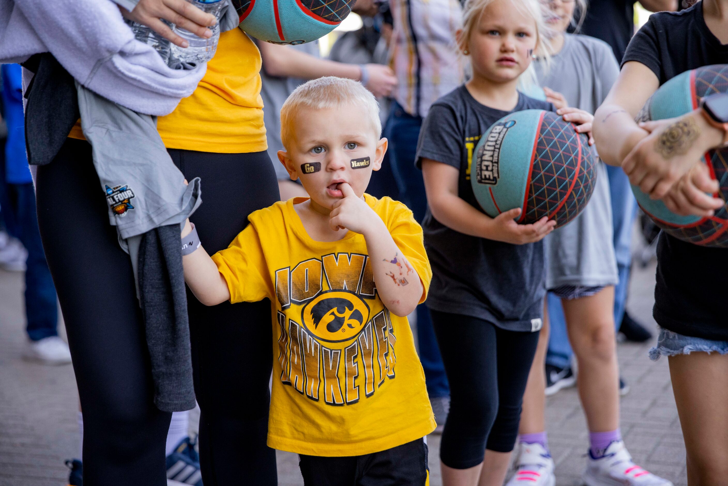 Gavin Bolome, 3, dons his Iowa gear after making his way from City Hall to Tourney Town at...