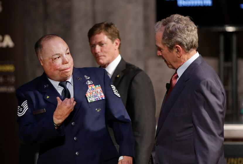 Technical Sgt.  Israel Del Toro speaks Thursday with former President George W. Bush and Ken...