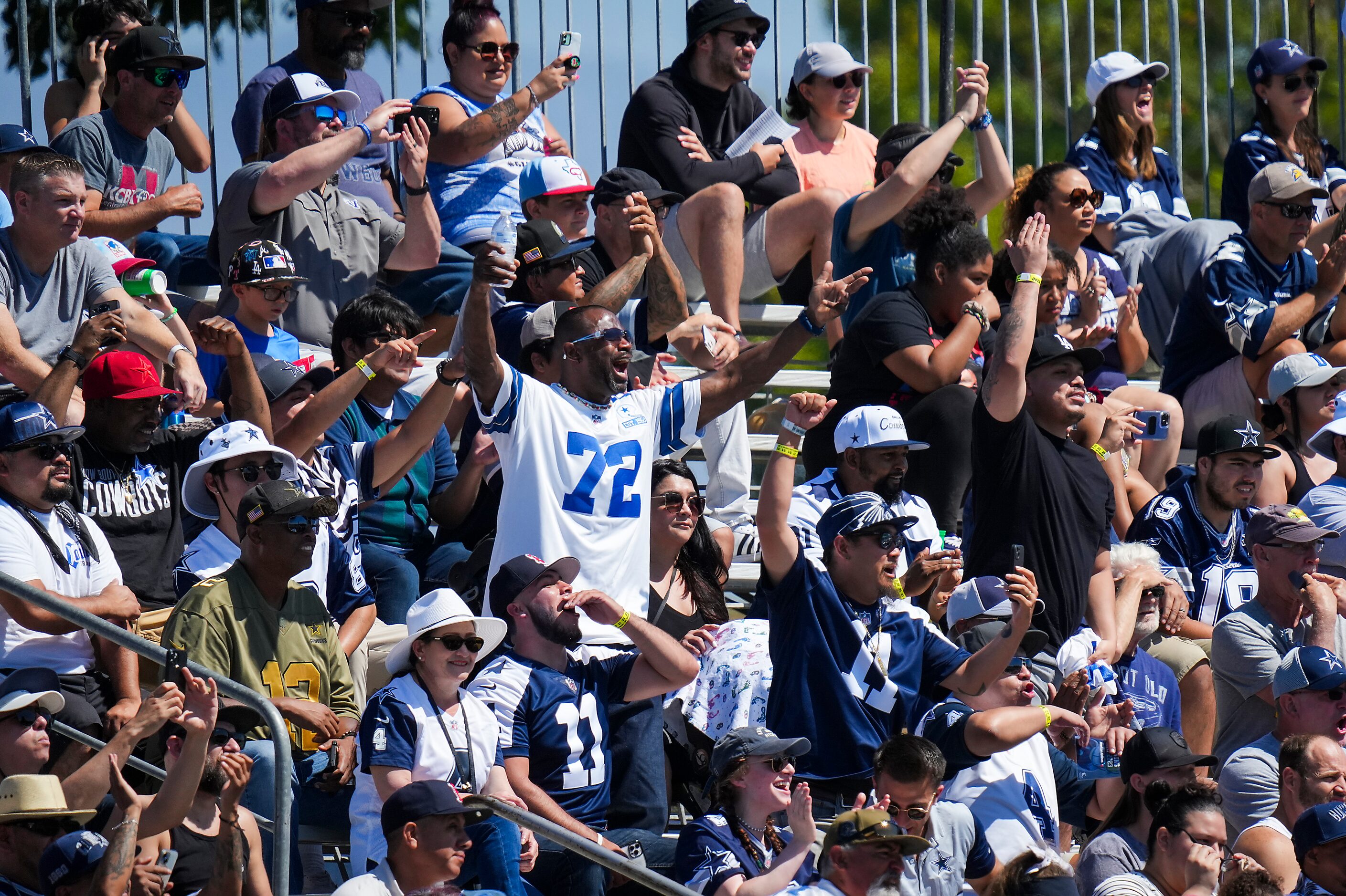 Fans cheer as the Dallas Cowboys take the field for a training camp practice on Saturday,...