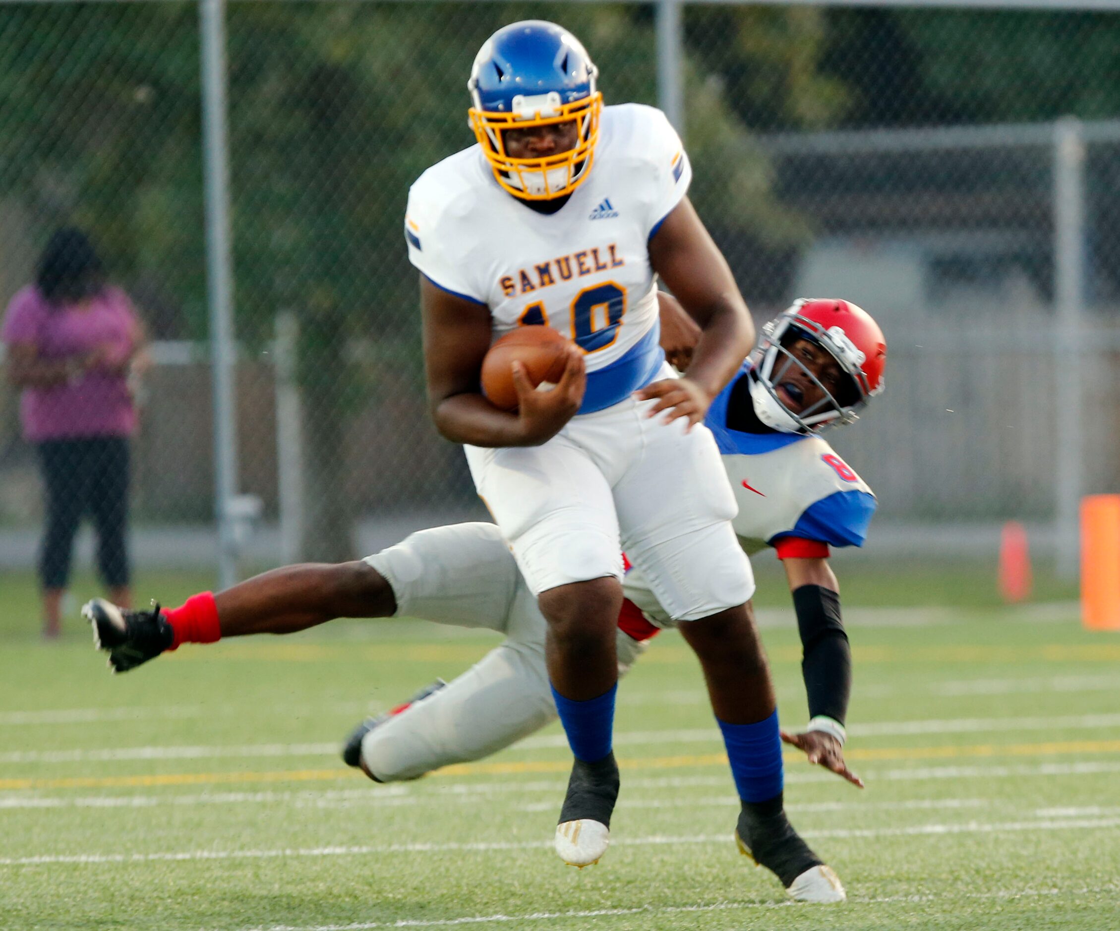 Samuell QB Roie White (10) evades Spruce defender Kelvin Jones (8) during the first half of...