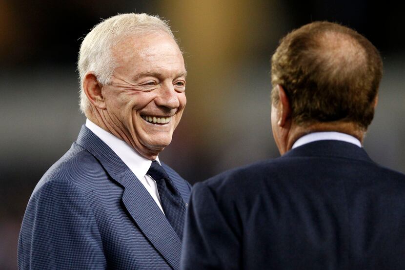 Dallas Cowboys owner Jerry Jones talks with television analyst Al Michaels before a game...