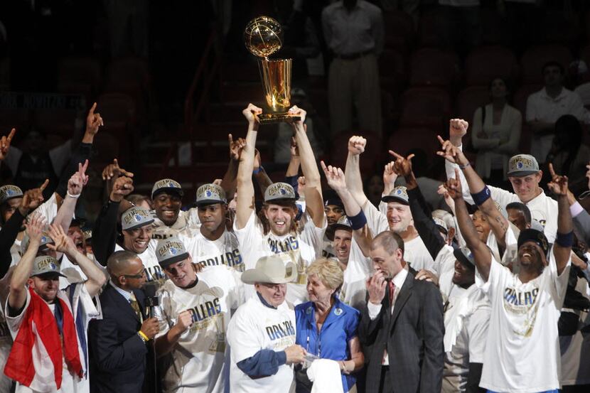 FILE - The Dallas Mavericks celebrate with the Larry O'Brien Trophy after winning Game 6 of...