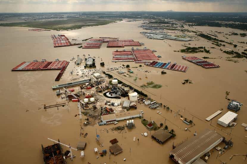 Barges are secured by tugboats in flood-swollen Burnet Bay along the Houston Ship Channel on...