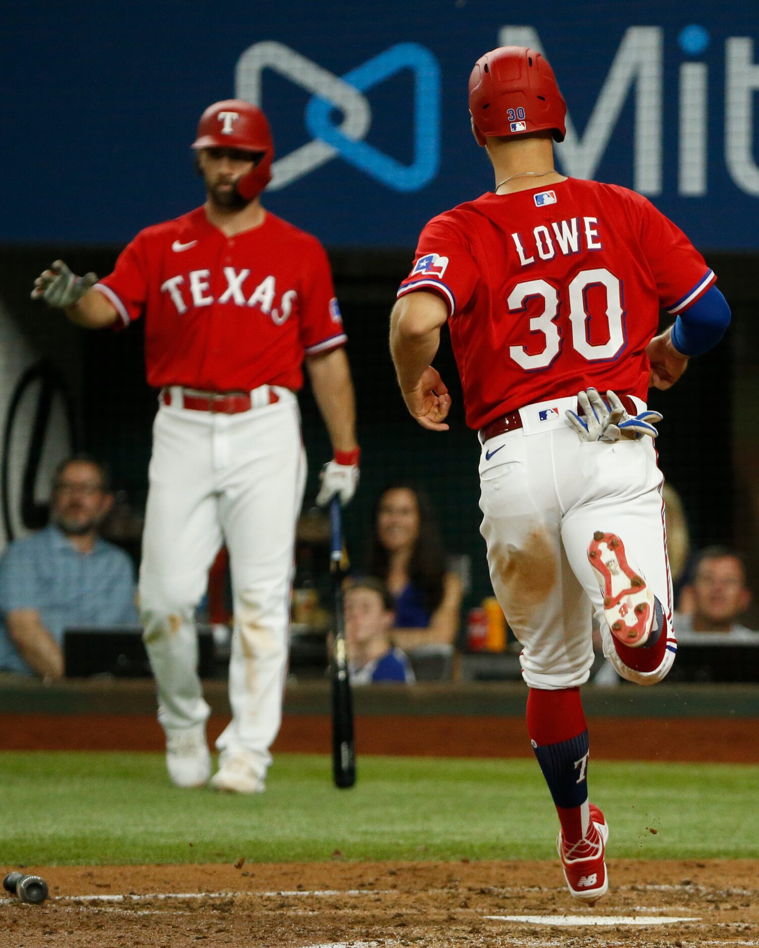 Texas Rangers first baseman Nate Lowe (30) touches home plate after an RBI double from Texas...