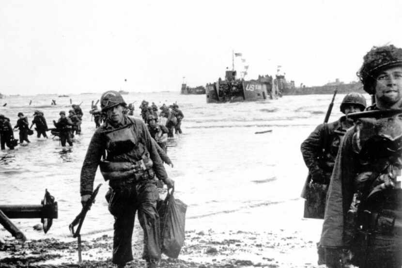  Carrying full equipment, American assault troops move onto a beachhead code-named Omaha...
