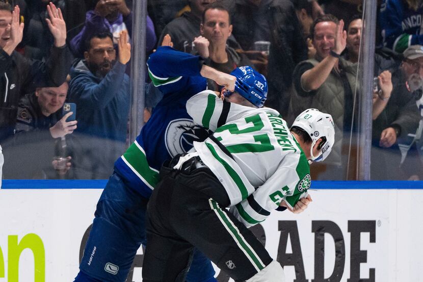 Vancouver Canucks' Ian Cole (82) and Dallas Stars' Mason Marchment (27) fight during the...