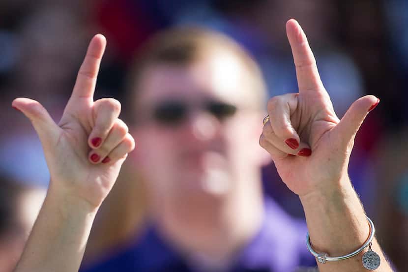 Texas Tech fans hold "Guns Up" before an NCAA football game against TCU at Amon G. Carter...
