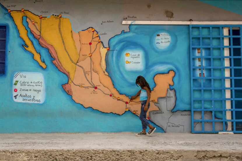 A girl passes a mural  showing travel routes at a shelter in Tenosique, Mexico. In 2014,...