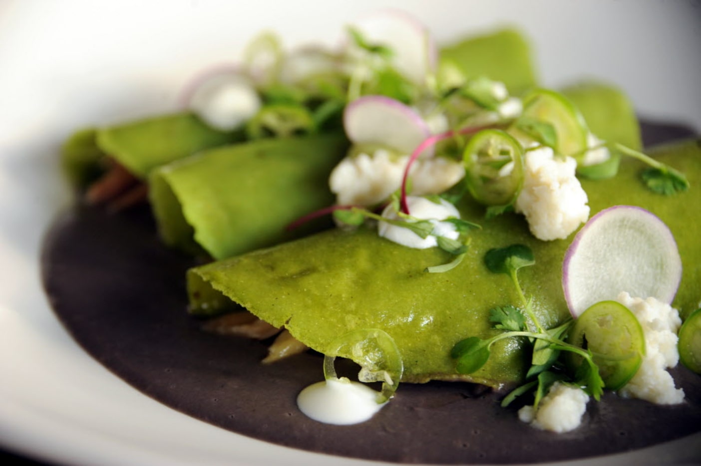 Madrina's enfrijolada is made with confit, cilantro tortilla, serrano chile, black bean...