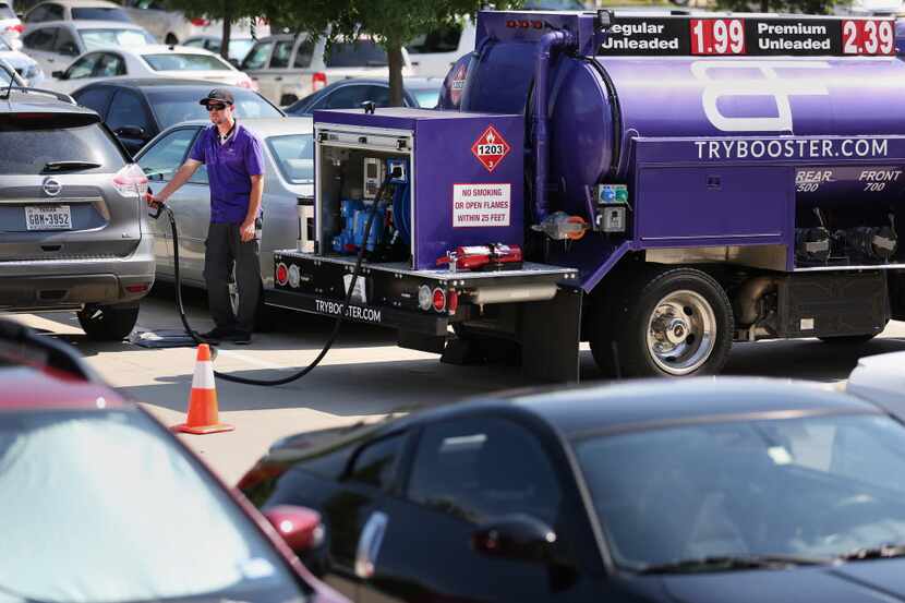 Booster Fuels driver Stephen Mainka pumps gas into customer cars at the offices of nThrive...