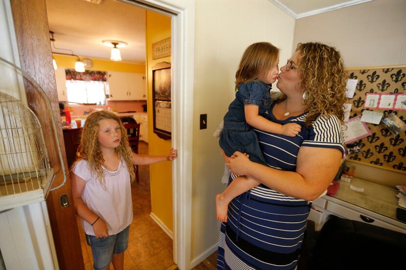 Foster parent Angela Cook, shown with two of her biological daughters, and her husband were...