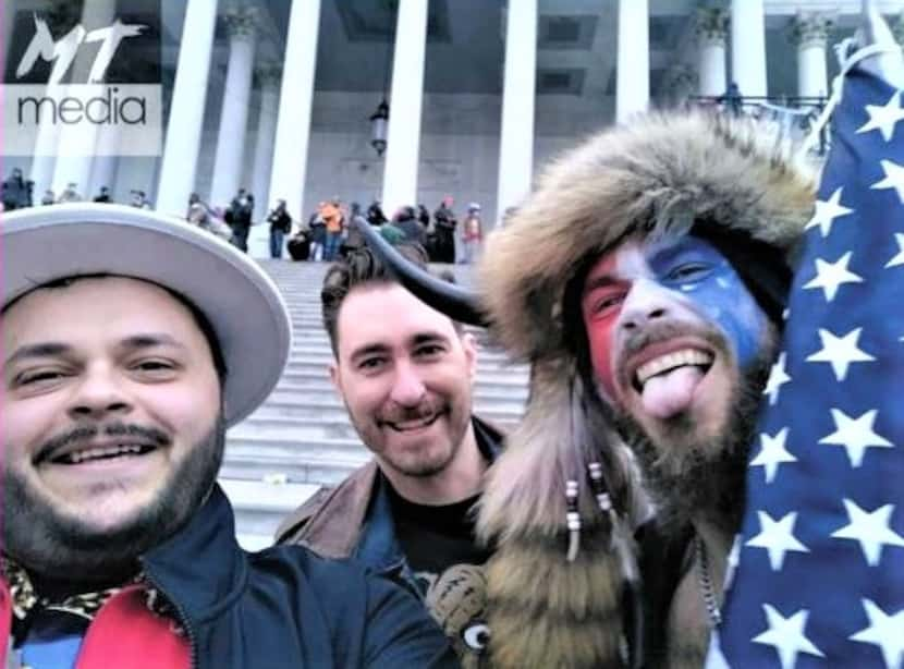 Nicholas DeCarlo (left) and Nicholas Ochs (rear) are seen with Jacob Chansley (right), who...