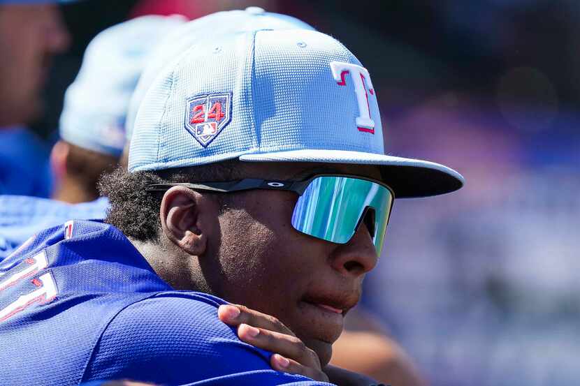Texas Rangers infielder Sebastian Walcott watches from the dugout during the first inning of...