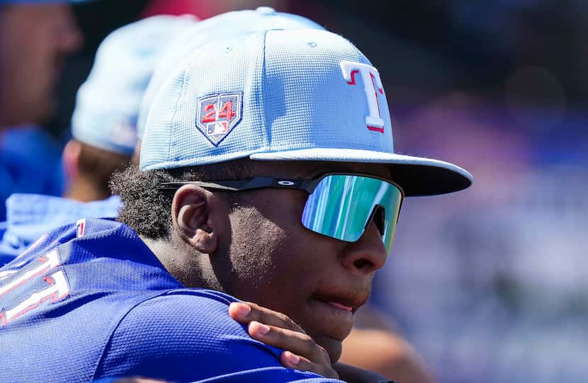 Texas Rangers infielder Sebastian Walcott watches from the dugout during the first inning of...