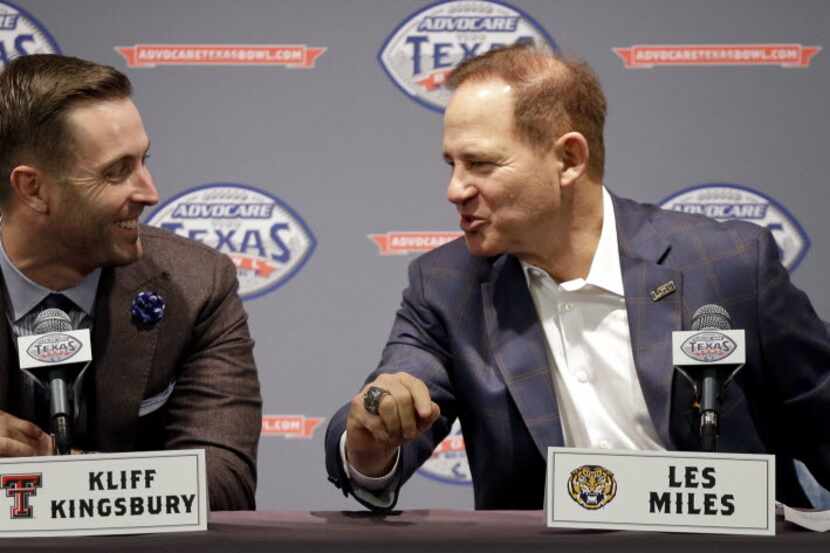 LSU coach Les Miles, right, talks with Texas Tech coach Kliff Kingbury's during a Texas Bowl...