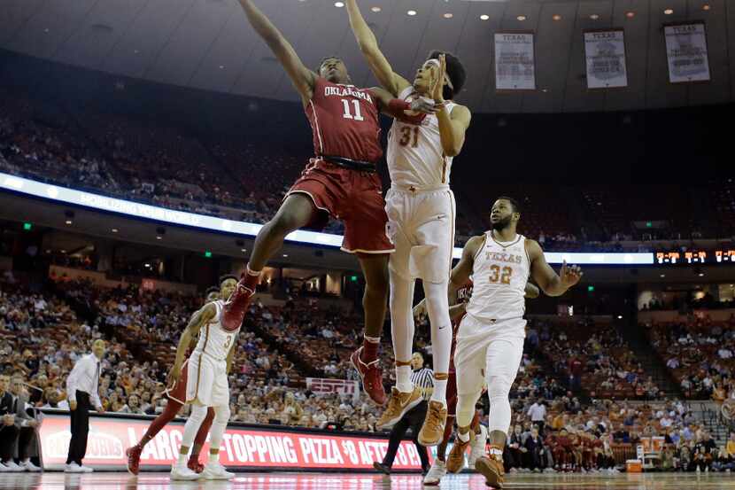 Oklahoma forward Kristian Doolittle (11) shoots past Texas forward Jarrett Allen (31) during...