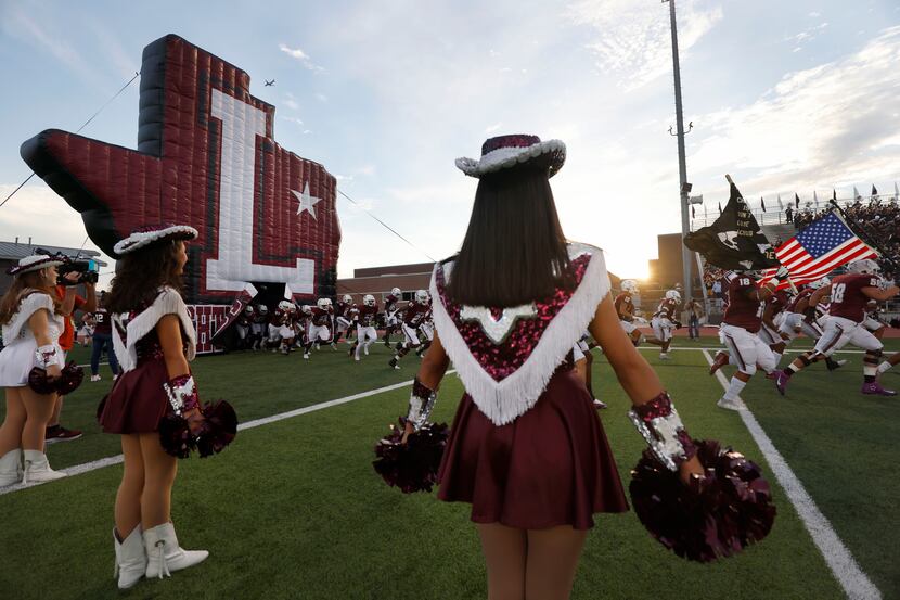 The Farmerette Drill team lines the entrance fo the Lewisville football team prior to...