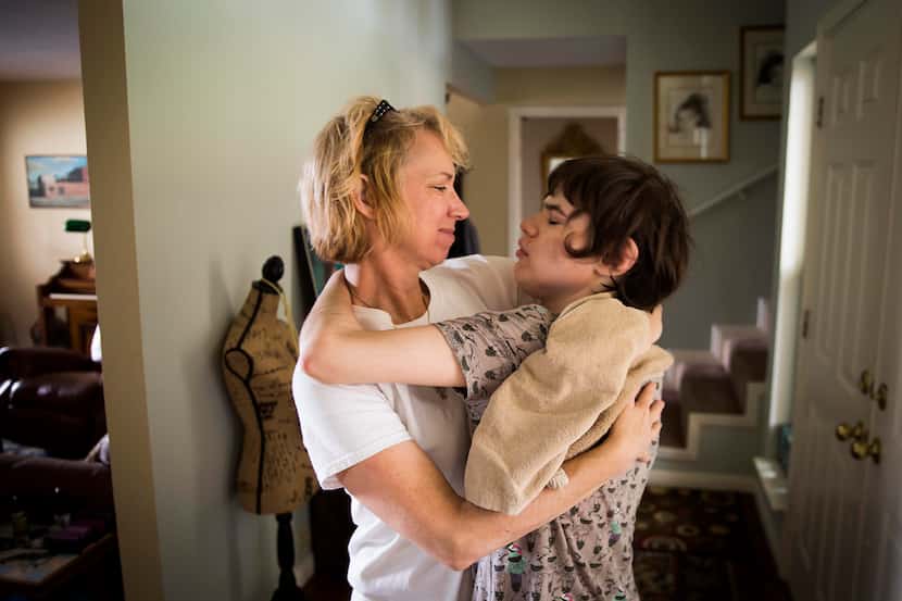 Christy Zartler hugs her daughter Kara after suctioning Kara's stuffy nose. Kara had come...
