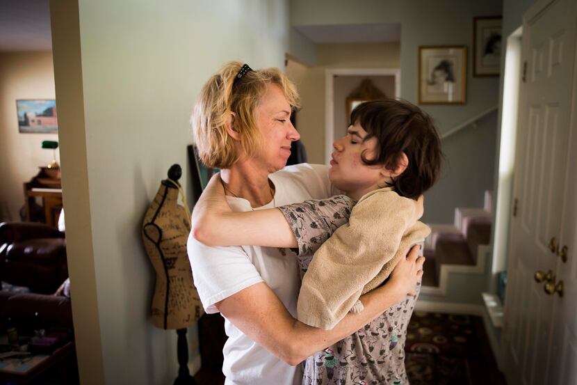 Christy Zartler hugs her daughter Kara after suctioning Kara's stuffy nose. Kara had come...