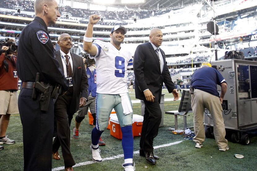 Dallas Cowboys quarterback Tony Romo (9) smiles and pumps his fist as he exits the field in...