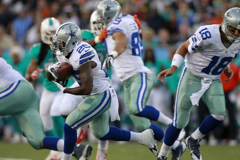 Dallas Cowboys running back Lance Dunbar (25) takes the hand off from quarterback Kyle Orton...