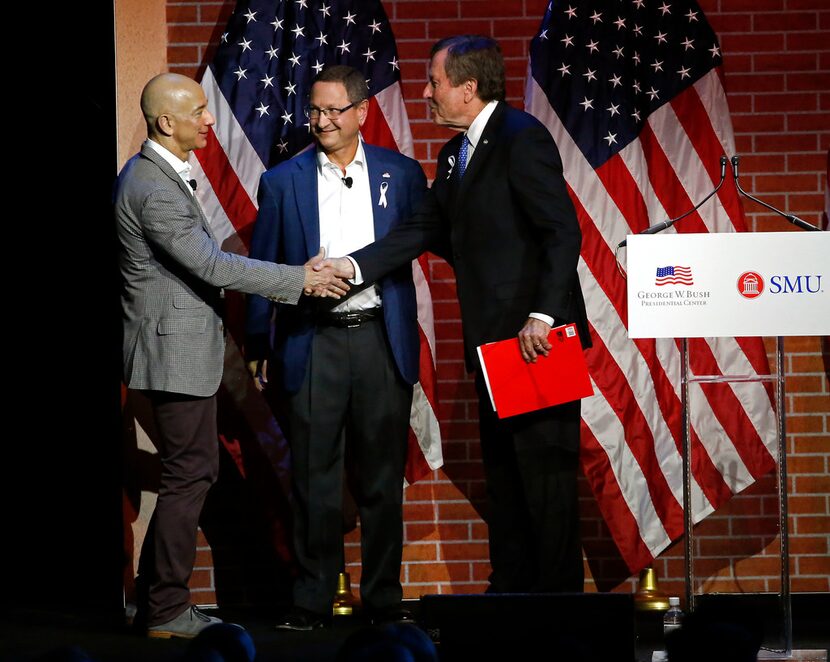 Jeff Bezos, Chairman and CEO of Amazon, left, shakes hands with Gerald Turner, president of...