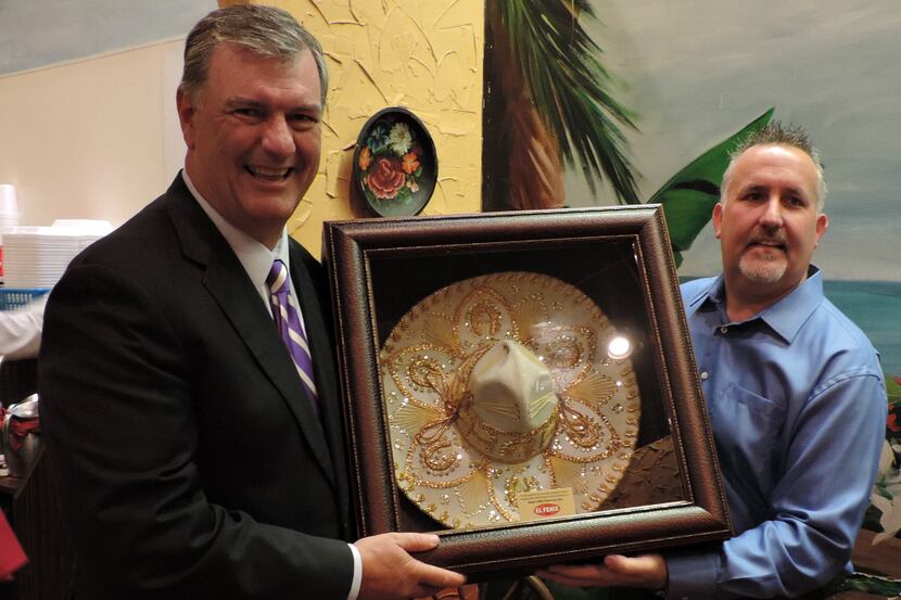  Steve Chambers, director of operations at El Fenix, gives Dallas Mayor Mike Rawlings the...