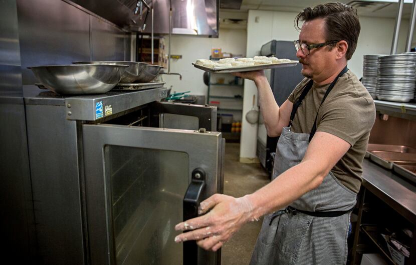 Chef Tim Byres  places buttermilk biscuits into an oven at Chicken Scratch restaurant. 