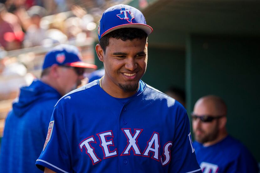 Texas Rangers pitcher Yohander Mendez smiles in the dugout during the third inning of a...