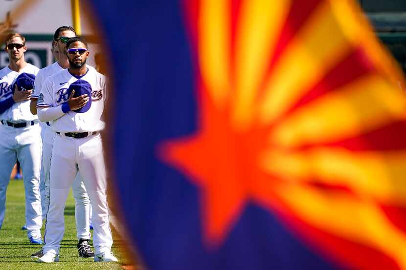 FILE - Rangers shortstop Elvis Andrus stands with teammates behind the Arizona state flag...