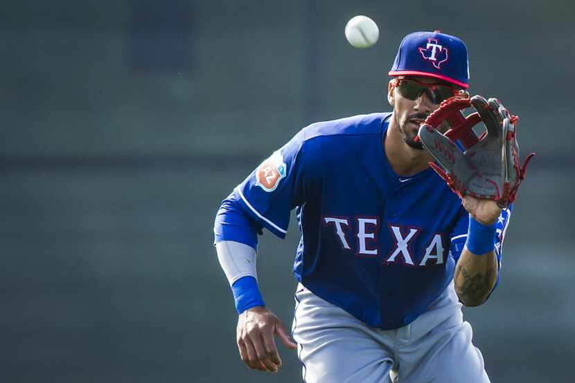 Texas Rangers outfielder Ian Desmond catches a fly ball while participating in a fielding...