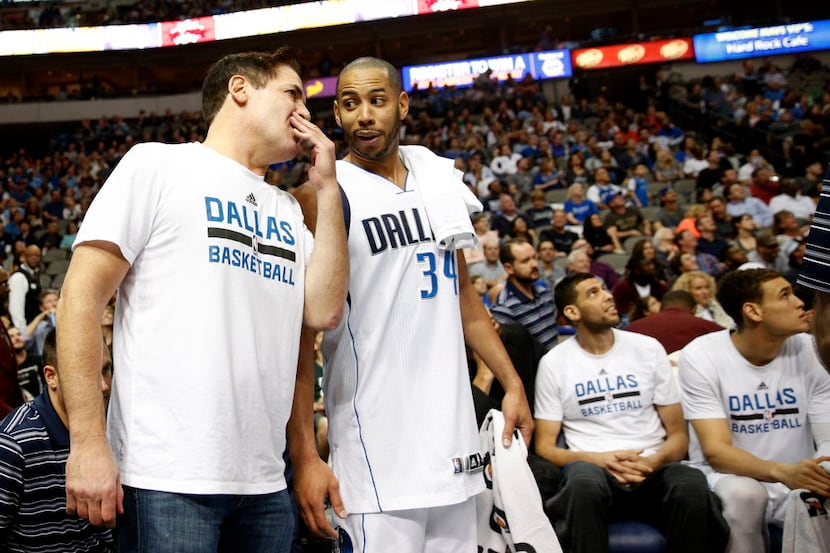 Dallas Mavericks owner Mark Cuban talks to Dallas Mavericks guard Devin Harris (34) during...