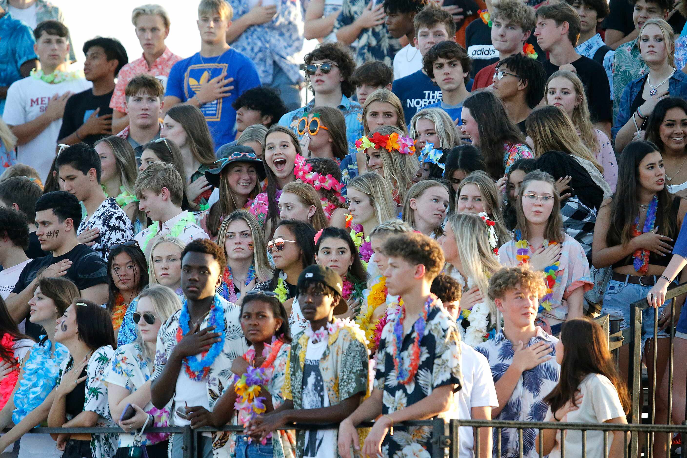 The Melissa High School student section stands at attention during the national anthem as...