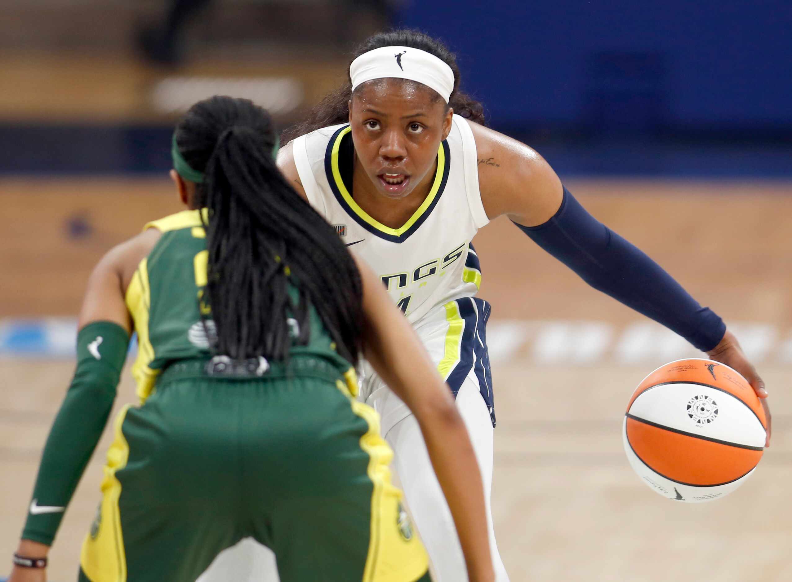 Dallas Wings guard Arike Ogunbowale (24) brings the ball to mid-court as she is defended by...