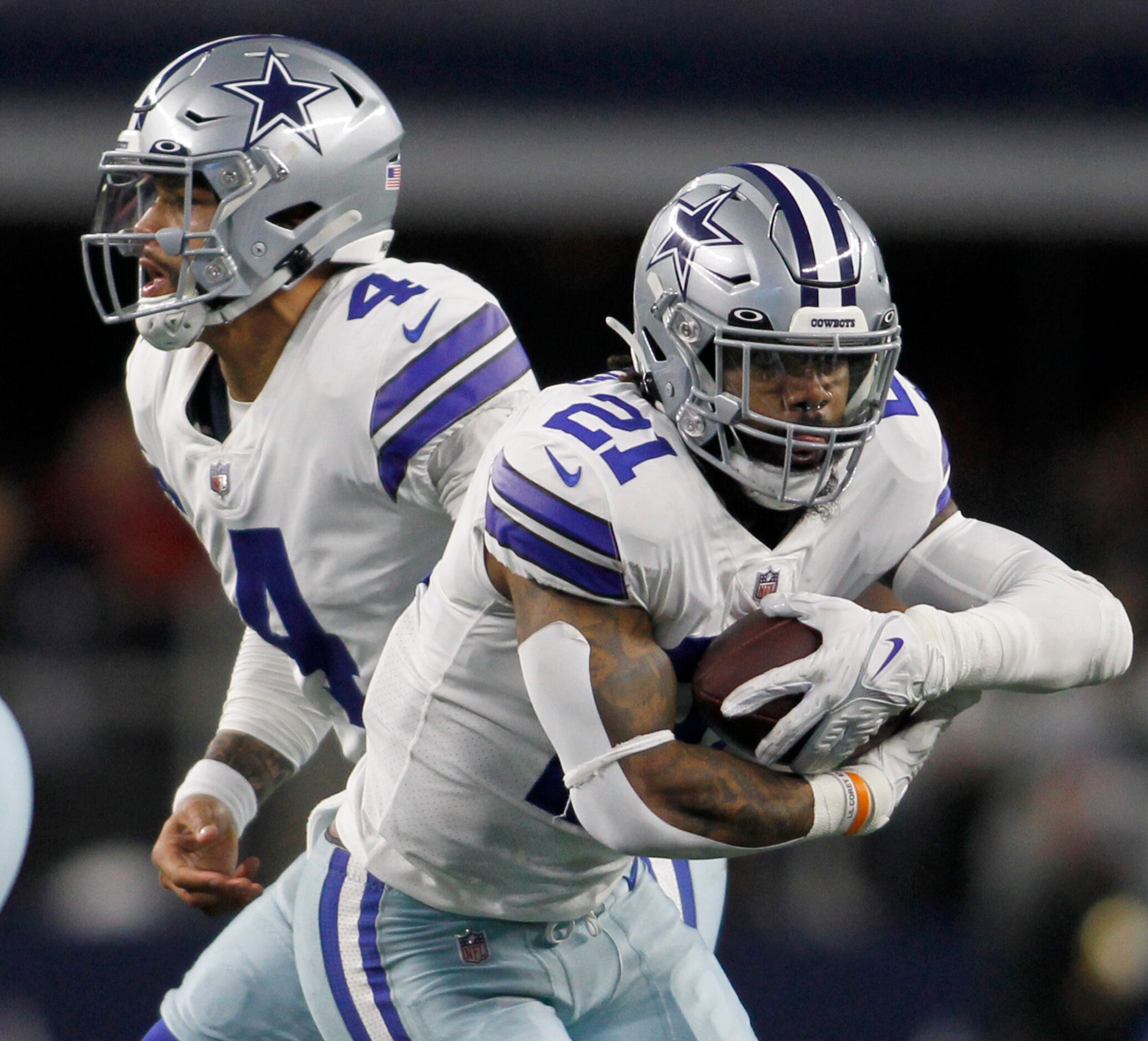 Dallas Cowboys running back Ezekiel Elliott (21) takes the handoff from quarterback Dak...