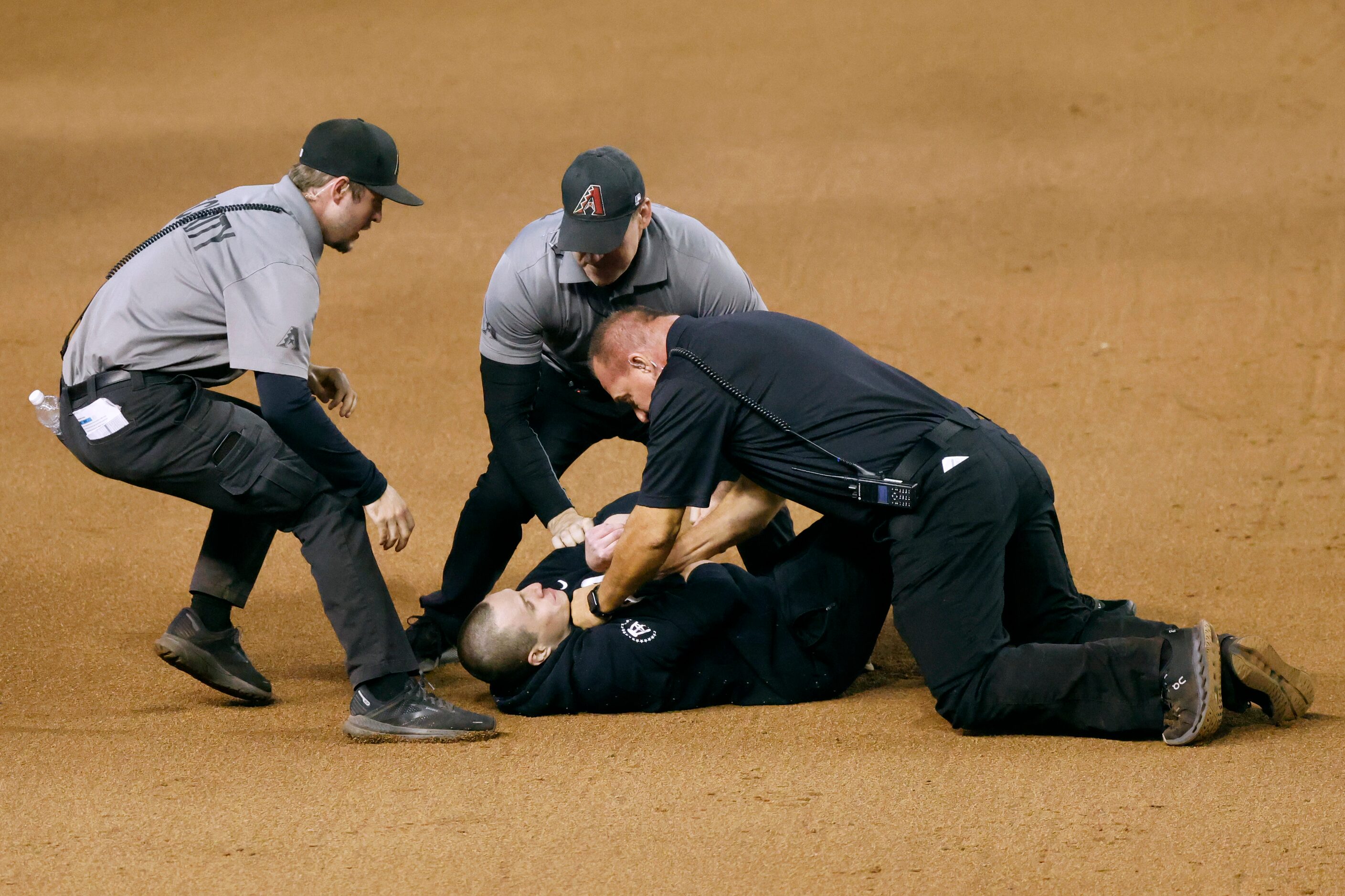 Security apprehends a fan who ran onto the field during Game 4 of the World Series between...