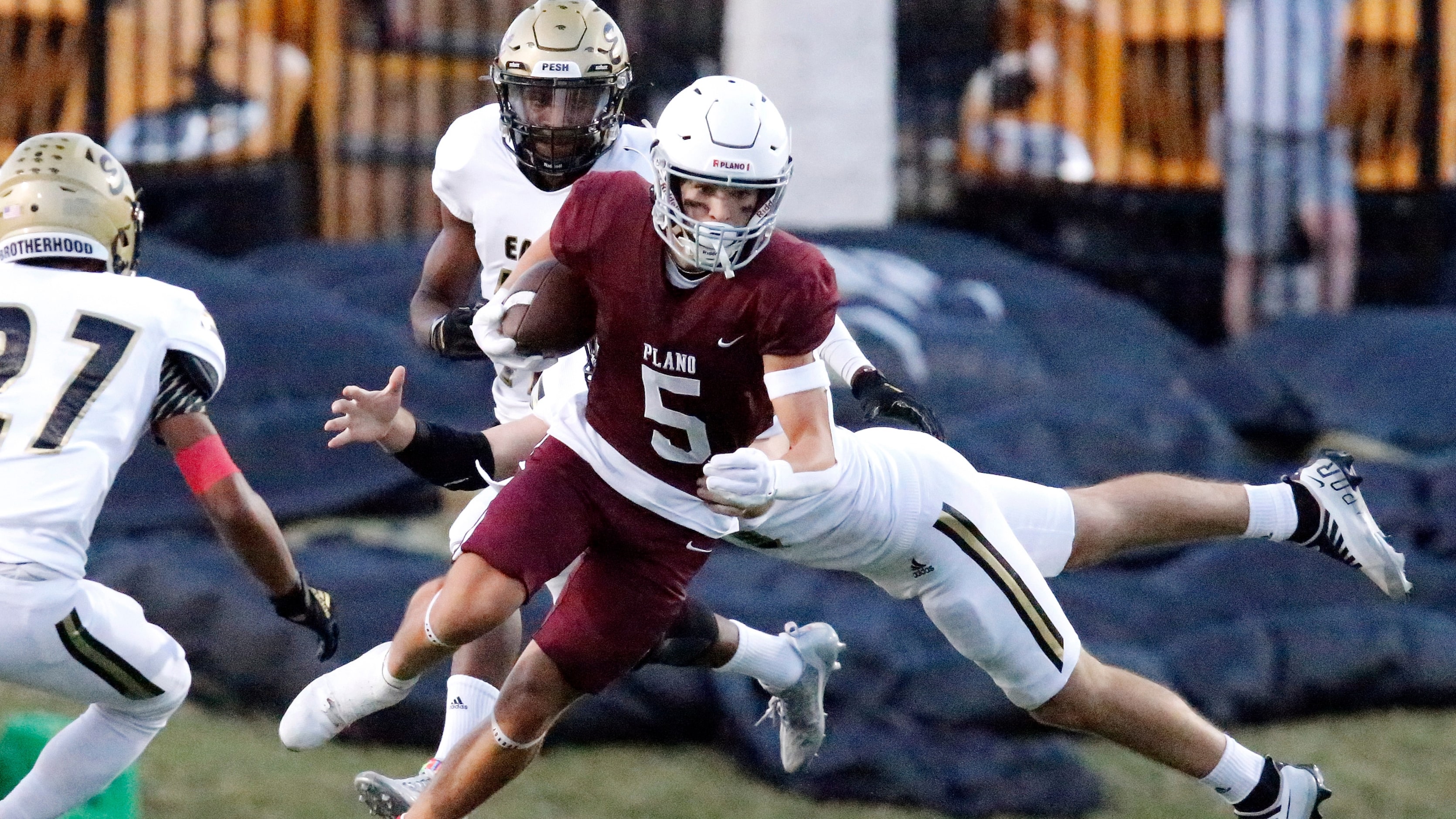 Plano Senior High School wide receiver Anthony Howard (5) is slowed down by Plano East High...