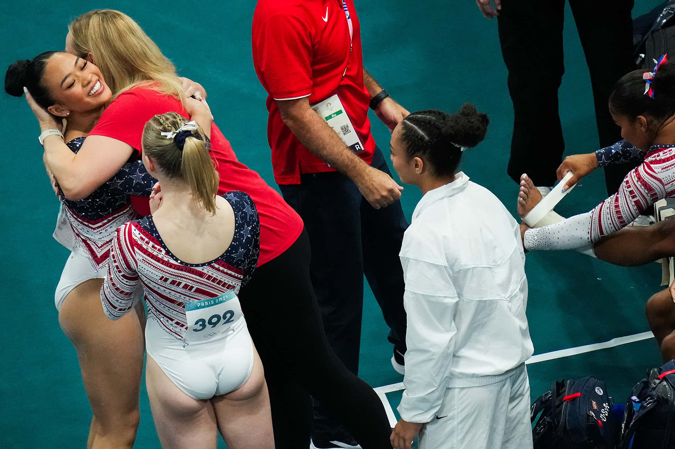 Suni Lee of the United States hugs coach Cecile Landi after competing on the balance beam...