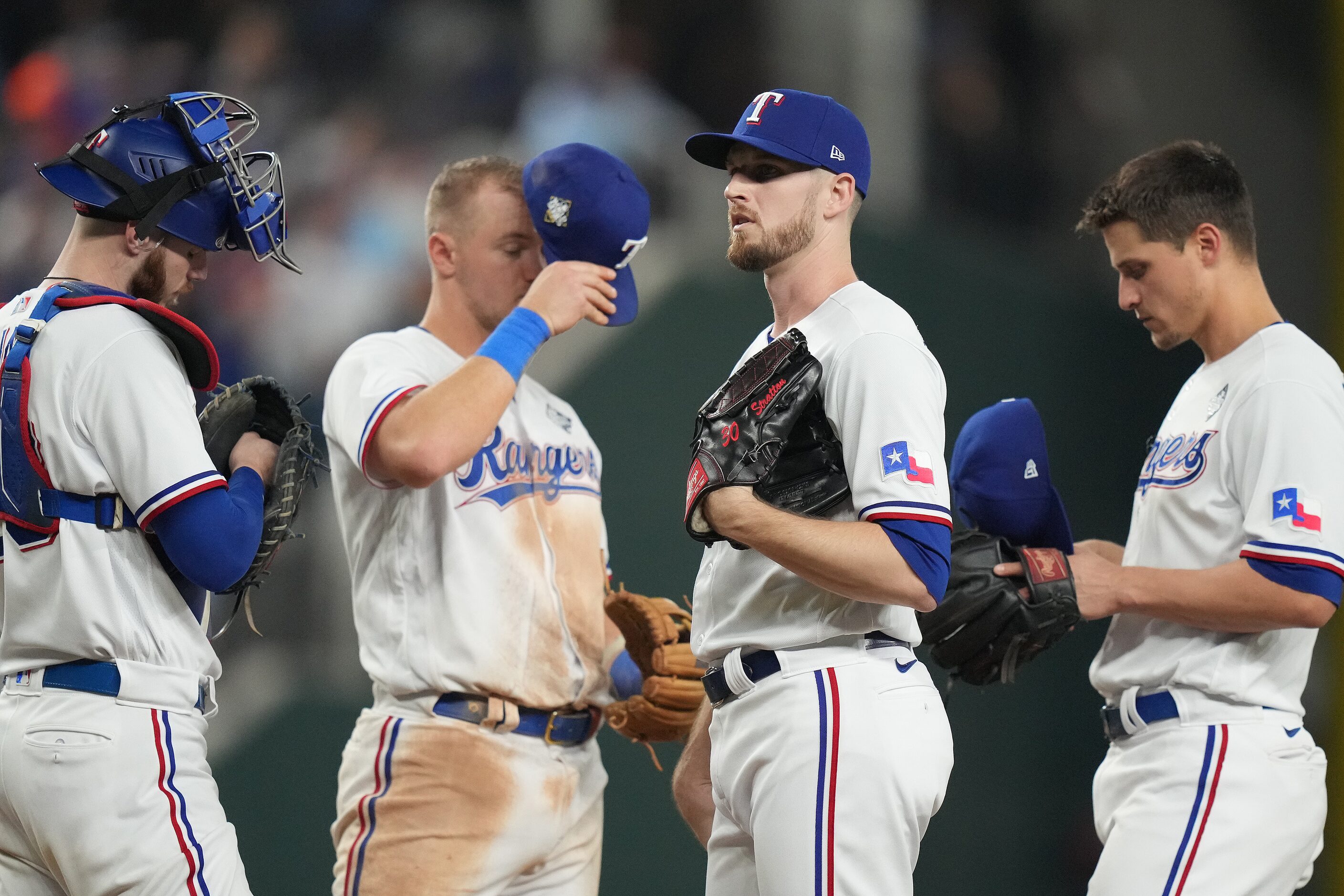 Texas Rangers relief pitcher Chris Stratton waits as manager Bruce Bochy comes to pull him...