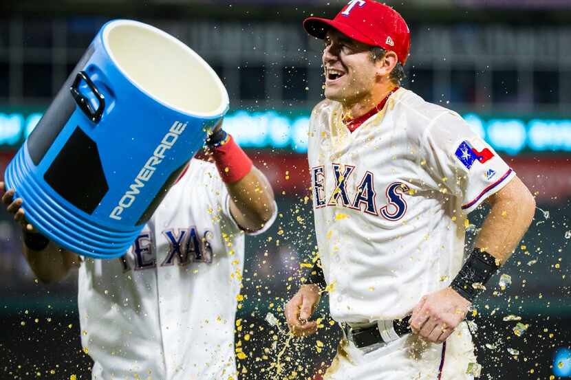 Texas Rangers outfielder Jared Hoying is doused with sports drink after a 9-3 victory over...