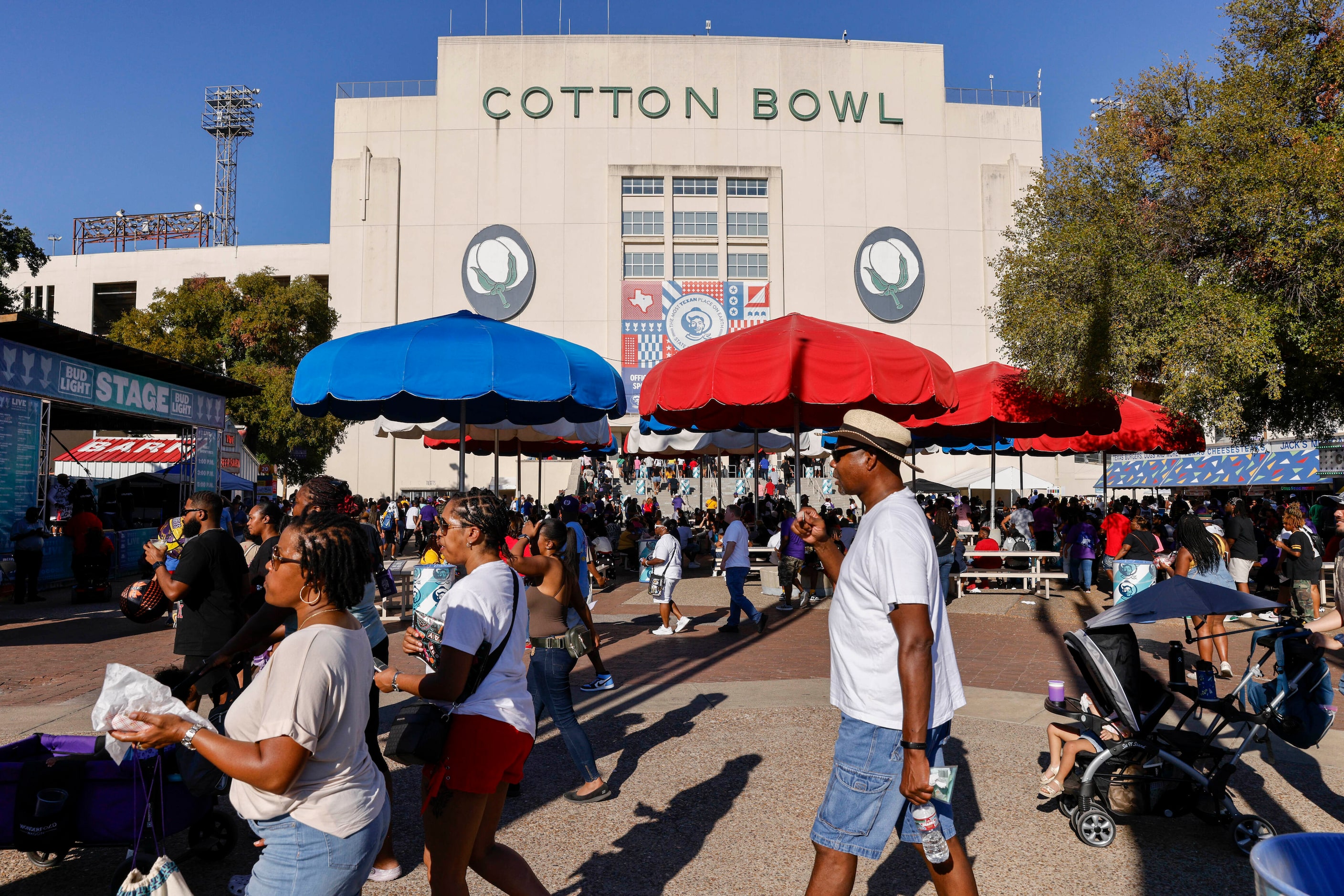 Fairgoers make their way around the Cotton Bowl before the State Fair Classic between...