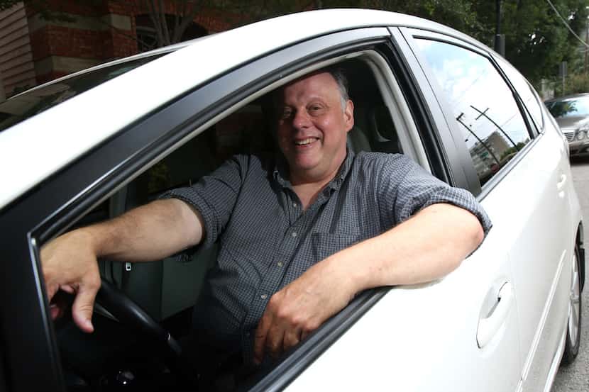 Lee Robertson, 57-year-old Lyft driver, poses for a photograph in his car in Dallas on...