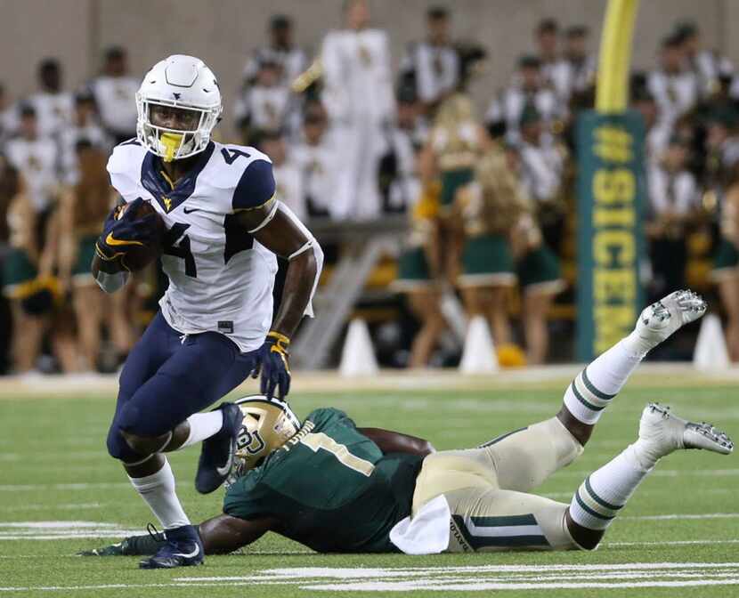 West Virginia running back Kennedy McKoy (4) runs past Baylor linebacker Taylor Young (1) in...
