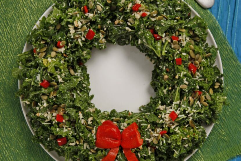 A Christmas Kale Salad Wreath uses red bell pepper feast for the ornaments and bow.