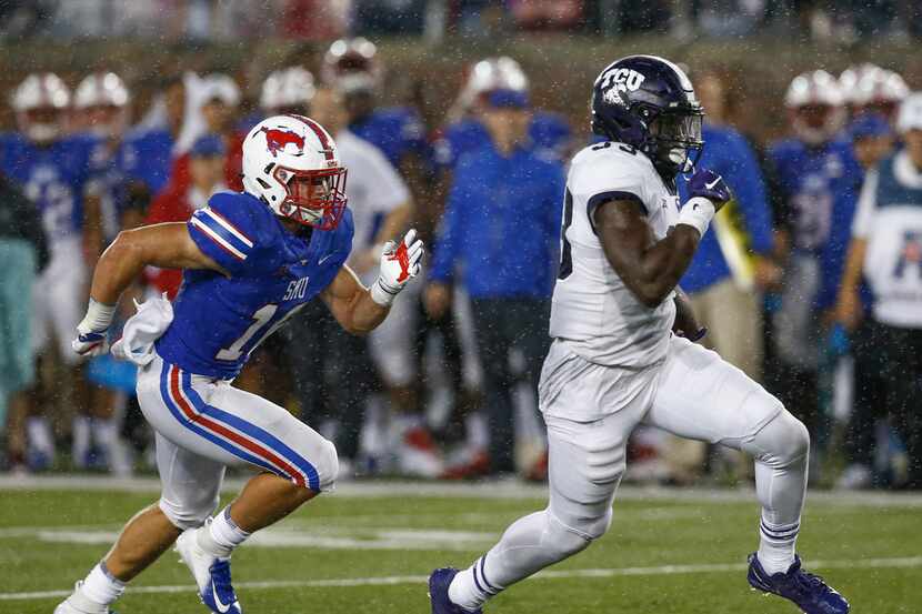 TCU running back Sewo Olonilua (33) runs past SMU linebacker Trevor Denbow (16) during the...