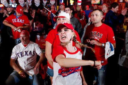 Texas Rangers baseball fan Lauren Schrimsher, center, reacts with
sadness and anger as...