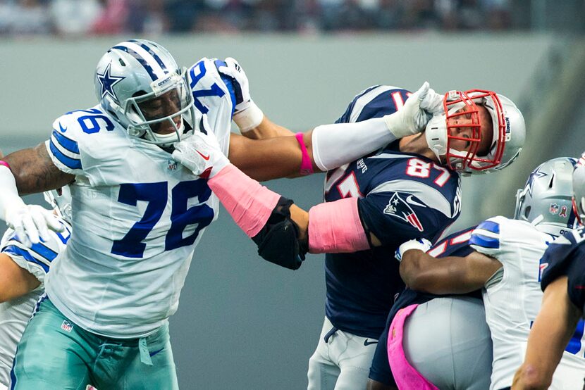 Dallas Cowboys defensive end Greg Hardy (76) is held by New England Patriots tight end Rob...