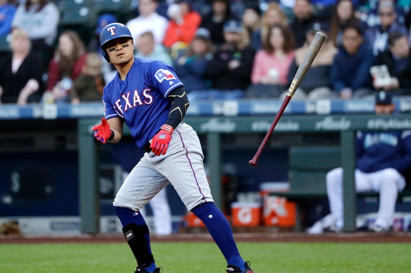 Texas Rangers' Shin-Soo Choo tosses aside his bat after walking against the Seattle Mariners...