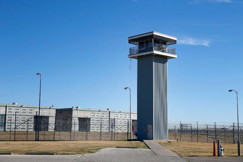 A guard tower and razor wire-topped fences are part of the landscape at the Texas Department...