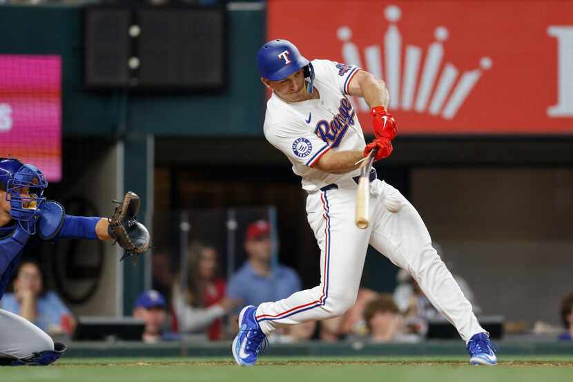 Texas Rangers designated hitter Wyatt Langford (36) collects his first career hit with a...